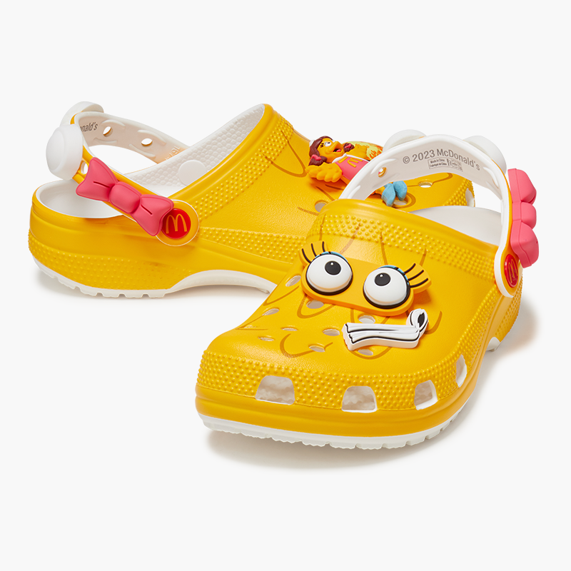 Alternate view of yellow birdie clog with pink bow detail and eye and white scarf jibbitz.