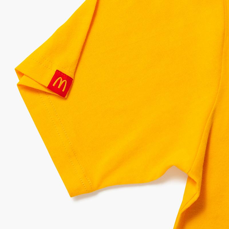 mustard yellow shirt with McDonald's nicknames listed: "Mickey D's", McDona's", "Macca's", "McD's", "McDo"
