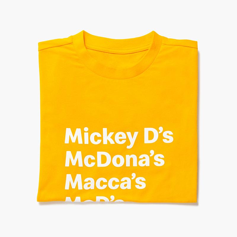 mustard yellow shirt with McDonald's nicknames listed: "Mickey D's", McDona's", "Macca's", "McD's", "McDo"