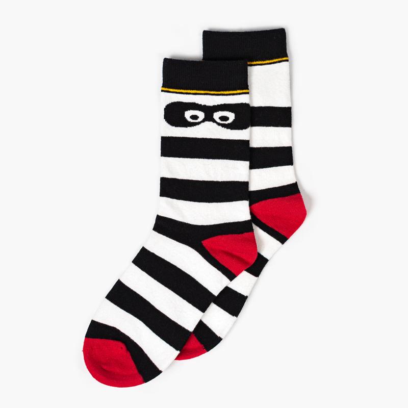 Striped black and white ankle socks with red toes and heels and Hamburglar eyes on the ankle