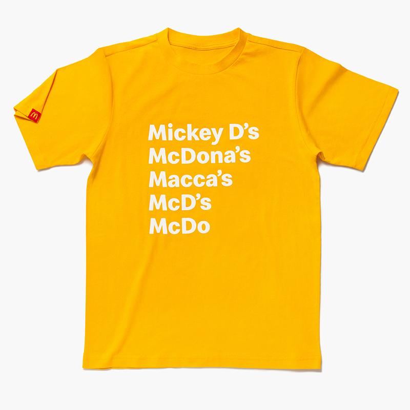 mustard yellow shirt with McDonald's nicknames listed: "Mickey D's", McDona's", "Macca's", "McD's", "McDo"