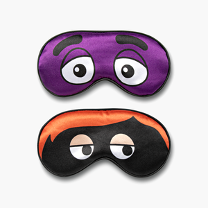 Set of 2 sleep masks. 1 Purple mask featuring Grimace's eyes and 1 black mask featuring Hamburglar's orange hair and masked eyes.