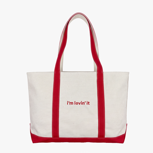 Front View of canvas tote bag with red trim and red handles, featuring the text 'i'm lovin' it' printed in red on the front, set against a plain white background.