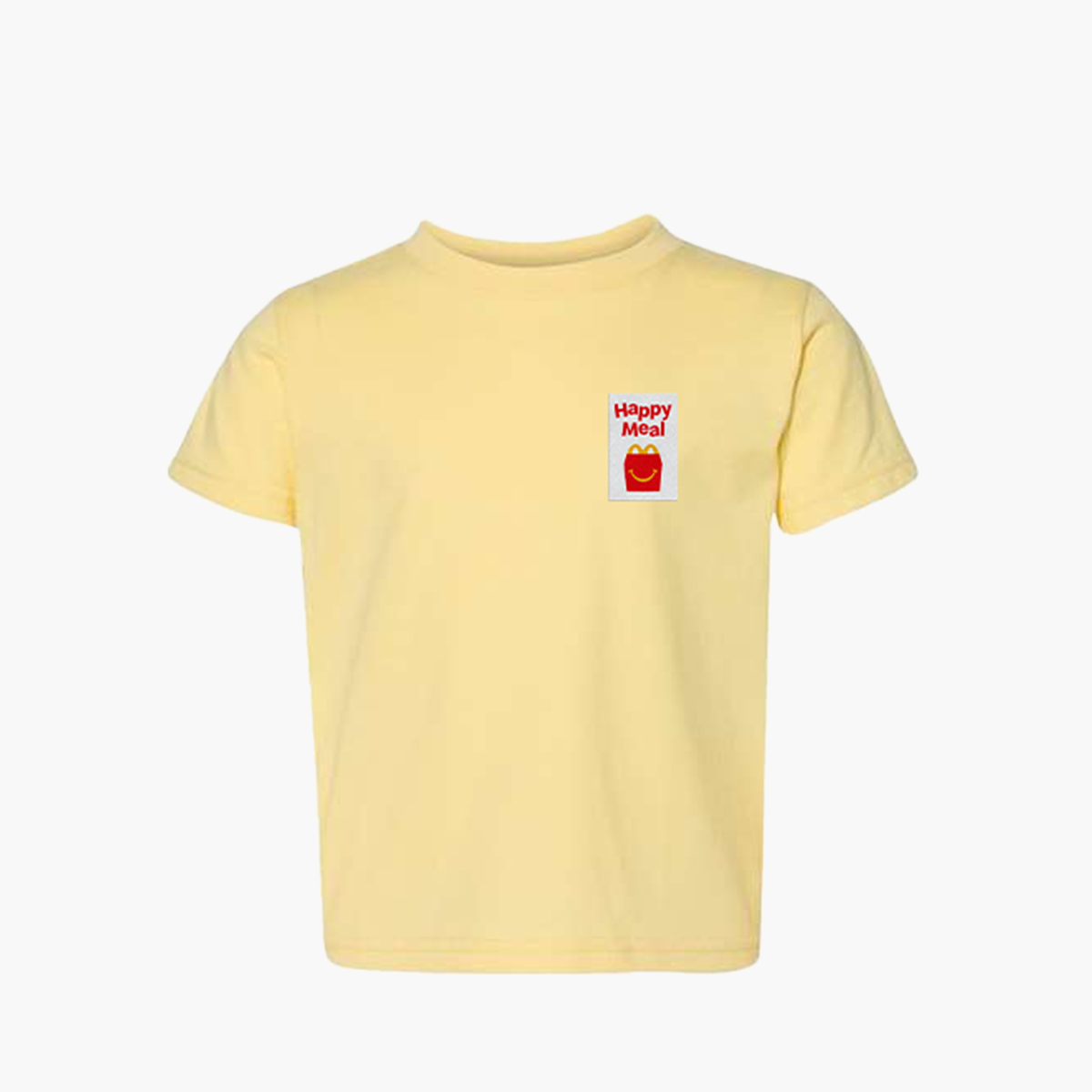 A pale yellow short-sleeve t-shirt with a small graphic on the left chest featuring the text 'Happy Meal' in red above a red McDonald's Happy Meal bag icon on a white background.