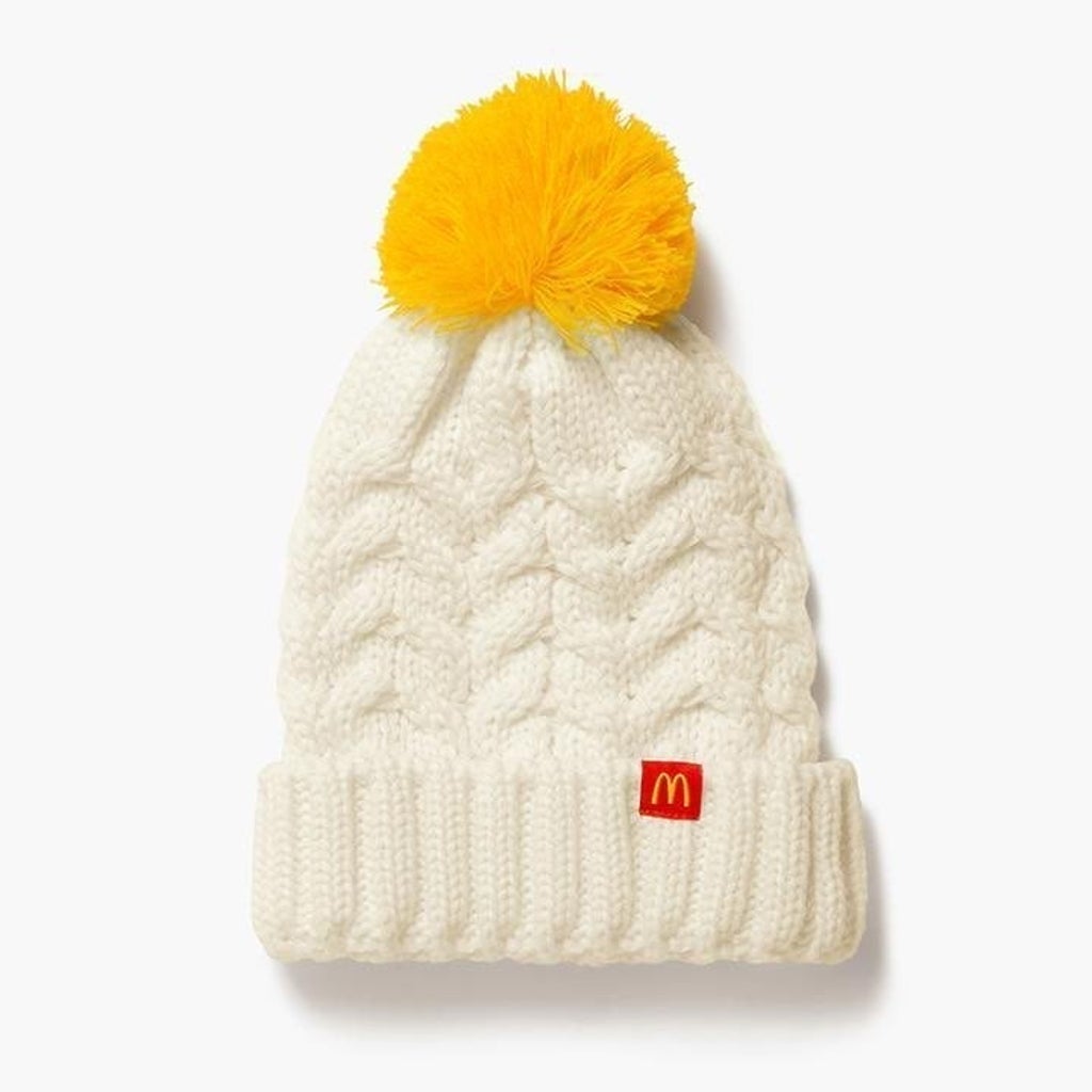 white chunky knit beanie hat with mustard yellow pompom and McDonald's logo on the cuff